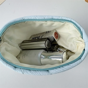 Inside view of blue quilted makeup bag showing spacious interior with cosmetics