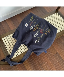 Detailed close-up of colorful wildflower embroidery on navy nylon tote bag material