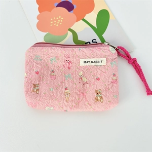 Detailed view of pink quilted canvas coin purse featuring cute cartoon animal prints