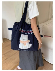 Detailed plush puppy embroidery on a navy canvas tote bag with Lucky puppy lettering