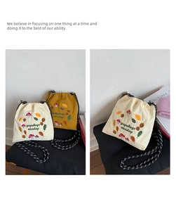 Detail of embroidered drawstring bucket bags in beige and yellow with woven straps