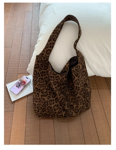 Detailed view of the large leopard print tote bag on a cozy wooden floor setting