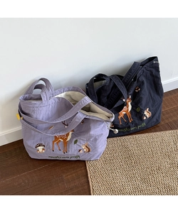 Detail of forest animal embroidery and drawstring closure on canvas tote bags