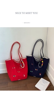 Detail of mushroom and dog embroidery on large canvas tote bags in red and blue