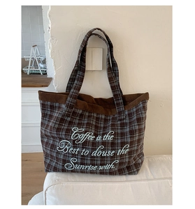 Close-up of retro plaid tote bag with corduroy trim and stylish white embroidery