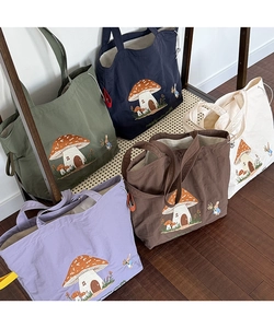 Detailed embroidery of mushroom house on canvas tote bags in five assorted colors