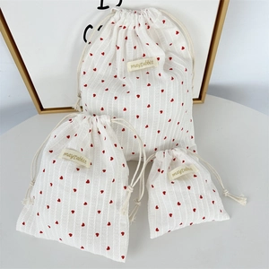 Detail showing set of three striped heart drawstring bags with textured fabric and labels