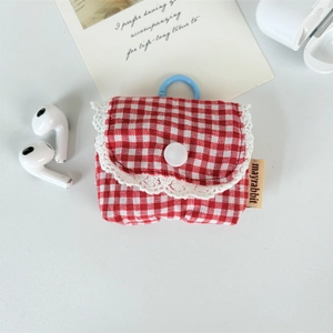 Close-up of red and white plaid fabric earphone case with lace trim and button closure