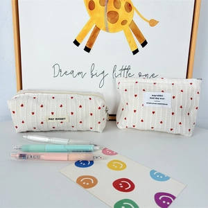 Minimalist heart print striped cosmetic bag set with two pouches on a desk