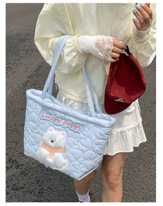 Detail of light blue quilted tote bag with cute plush puppy embroidery and Lucky puppy text