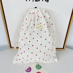 Close-up of drawstring closure on heart pattern cotton pouch with brand woven label