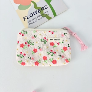 Close-up of a floral quilted canvas mini pouch with floral patterns and zipper detail