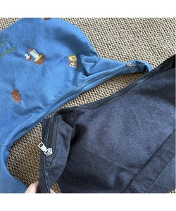 Gros plan de sacs cabas en denim japonais avec broderies de champignons et de fleurs