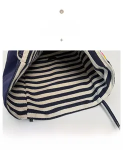Detail view of the blue and white striped lining with a vintage gold metal snap button