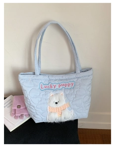 Detail of light blue quilted tote bag with Lucky Puppy plush embroidery and heart patterns