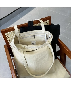 Detail of canvas tote bag interior showing the zipper closure and small inner pocket