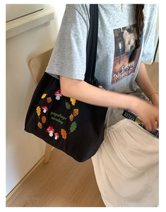 Close-up of colorful mushroom embroidery on a large black nylon tote shoulder bag