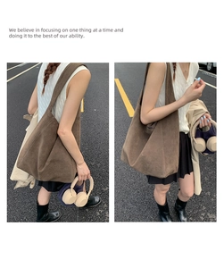 Detail of a large brown suede tote bag worn on shoulder in a street fashion setting