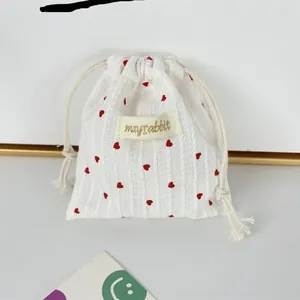 Macro detail of vertical stripe cotton drawstring bag with red heart pattern print