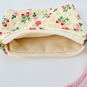 Detail of strawberry floral canvas coin purse showing inner lining and metal zipper