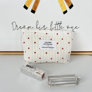 Detail of red heart embroidery on white waffle fabric toiletry bag with zipper
