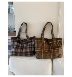 Detailed view of plaid wool tote bags with vintage embroidery and corduroy trim details