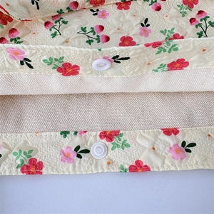 Detailed close-up of floral bento bag showing white plastic snap button and fabric texture