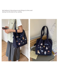 Detail of navy canvas tote bag with colorful cat and dessert cartoon embroidery