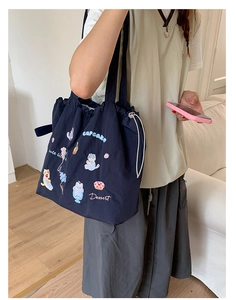 Close-up of navy canvas tote bag with detailed cartoon cat and cupcake embroidery