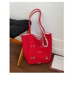 Close-up of red canvas bag with puppy and mushroom embroidery and happy day lettering
