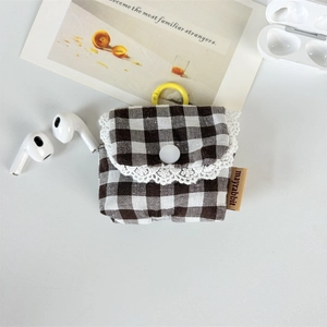 Detail of plaid earphone case with delicate lace edge and a yellow hanging hook