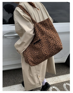 Close-up of leopard print tote bag featuring black branded woven label and large capacity