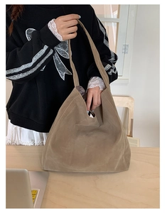 Detail of soft khaki suede tote bag with spacious interior and seamless shoulder strap