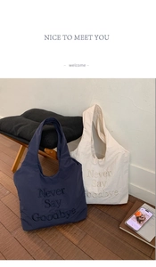 Detailed embroidery on blue and beige nylon tote bags in a minimalist interior setting