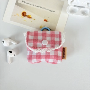 Close-up of pink checkered fabric earphone case with white lace trim and button closure
