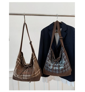 Detail view of plaid and corduroy shoulder bags with embroidery and ribbon accents