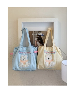 Detail of cute embroidered puppy on canvas drawstring tote bags in blue and yellow