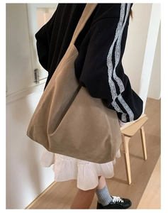 Detailed view of the large capacity khaki shoulder tote bag styled on a model's shoulder