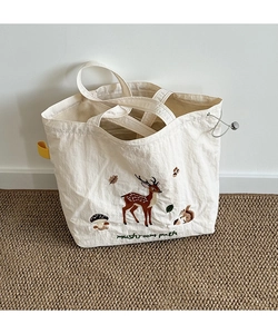 Close-up of forest animal embroidery and drawstring closure on white canvas tote bag