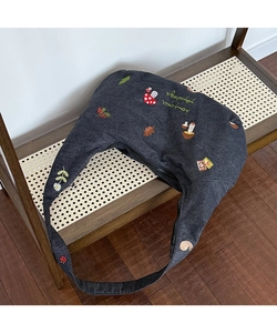Détail de la broderie champignon et feuille sur un sac bandoulière en toile gris foncé
