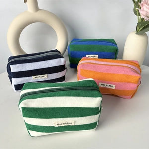 Detailed view of colorful striped towel fabric pouches with soft texture and brand label