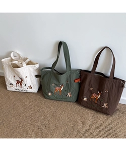 Detailed embroidery of deer and squirrel on canvas tote bags in white, green, and brown