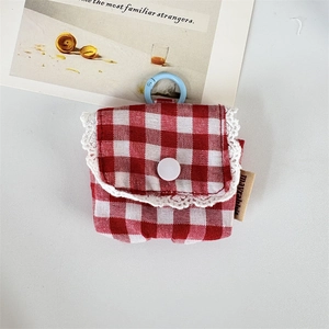 Detail of red gingham earphone pouch with white lace trim and light blue carabiner
