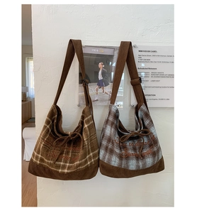 Detail of plaid canvas tote bags showing textured corduroy bottom and embroidery detail