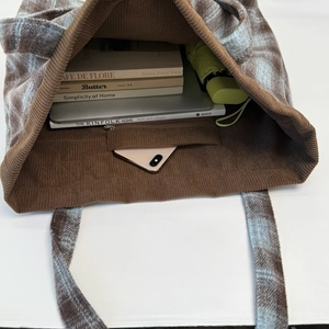 Plaid corduroy tote bag showing large capacity with laptop, books and umbrella