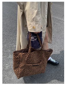 Detail of leopard print canvas tote bag featuring a front pocket and large capacity