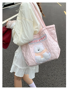 Close-up of pink quilted tote bag with lucky puppy embroidery and heart textures