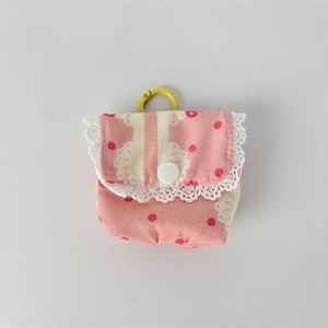 Close-up of pink floral earphone case with white lace edge and yellow hanging ring