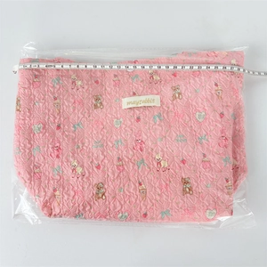 Pink quilted floral lunch bag with cartoon prints, measuring approximately 30cm in width