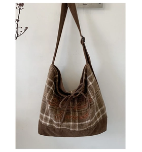 Detail of checkered corduroy shoulder bag with vintage patchwork and artistic embroidery